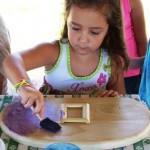 Abby painting her craft-picture frames with each child's picture in the center