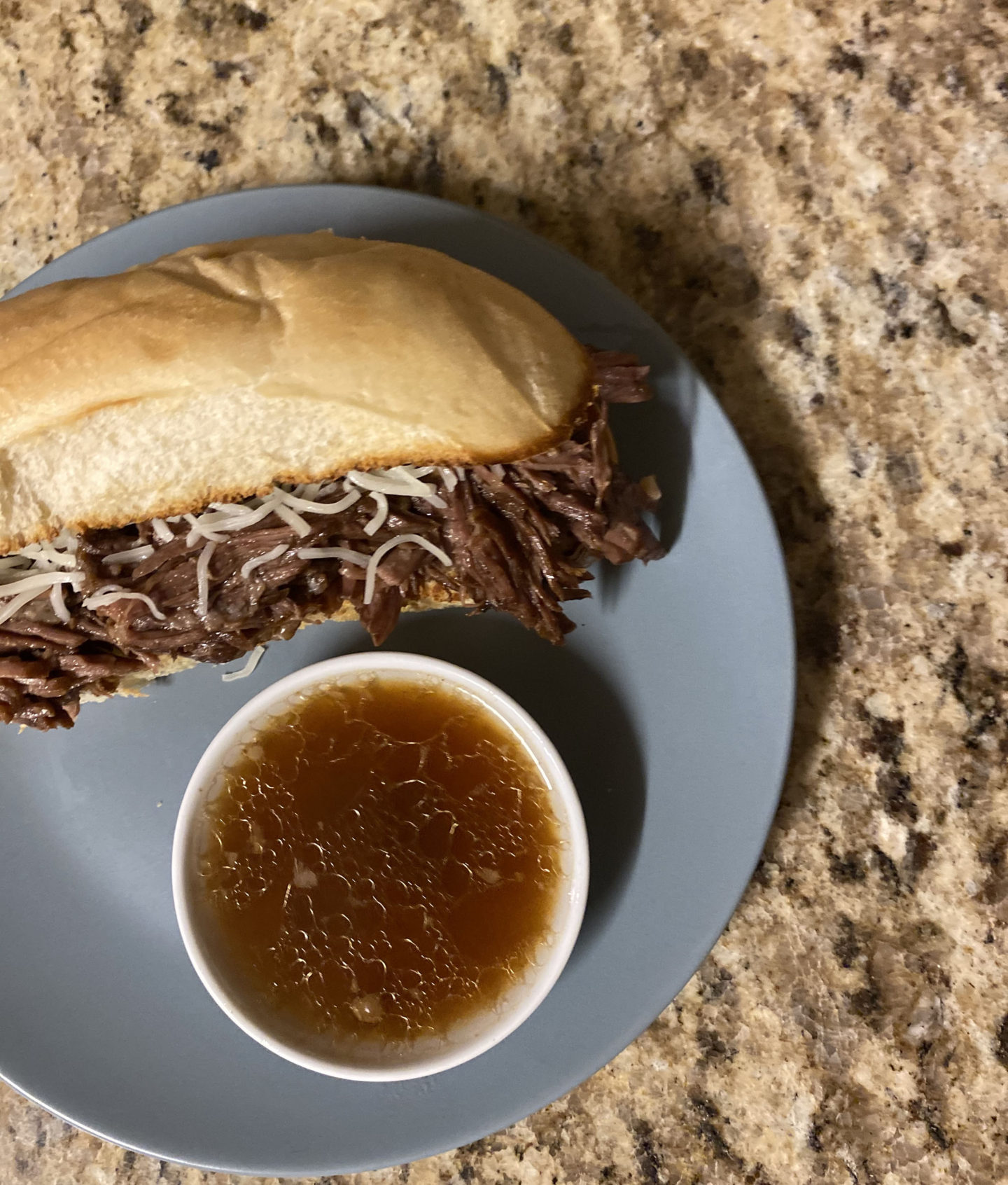 instant pot french dip sandwich with au jus dip on a kitchen counter