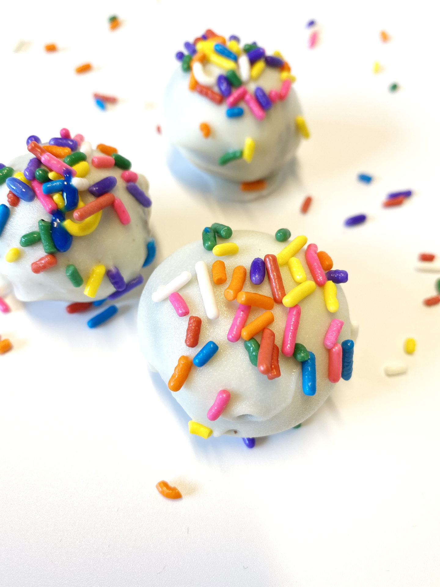  chocolate cake balls dipped in white chocolate and rainbow sprinkles 