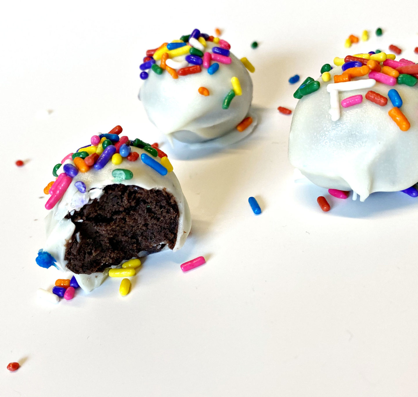 Candied cake balls dipped in white chocolate and sprinkles 