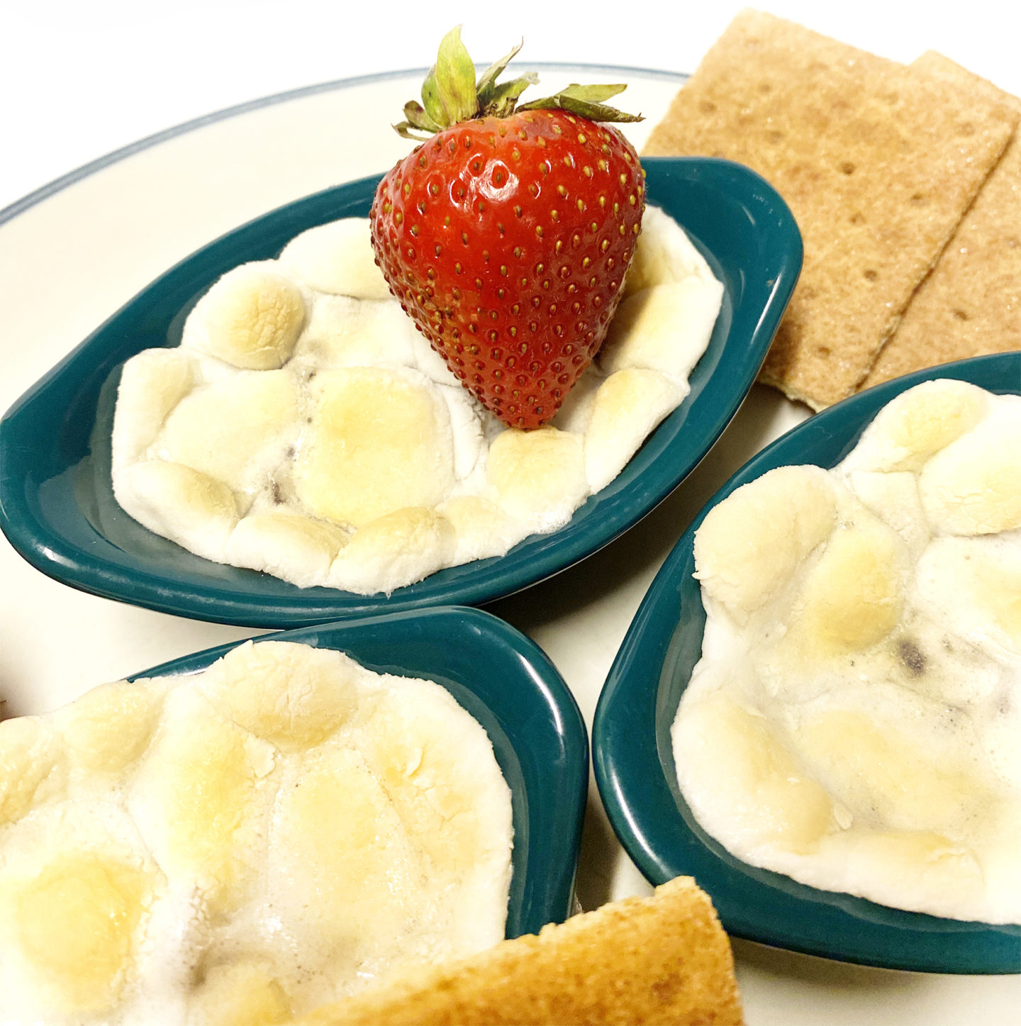 s'mores dip with graham crackers and strawberries in small dipping cups