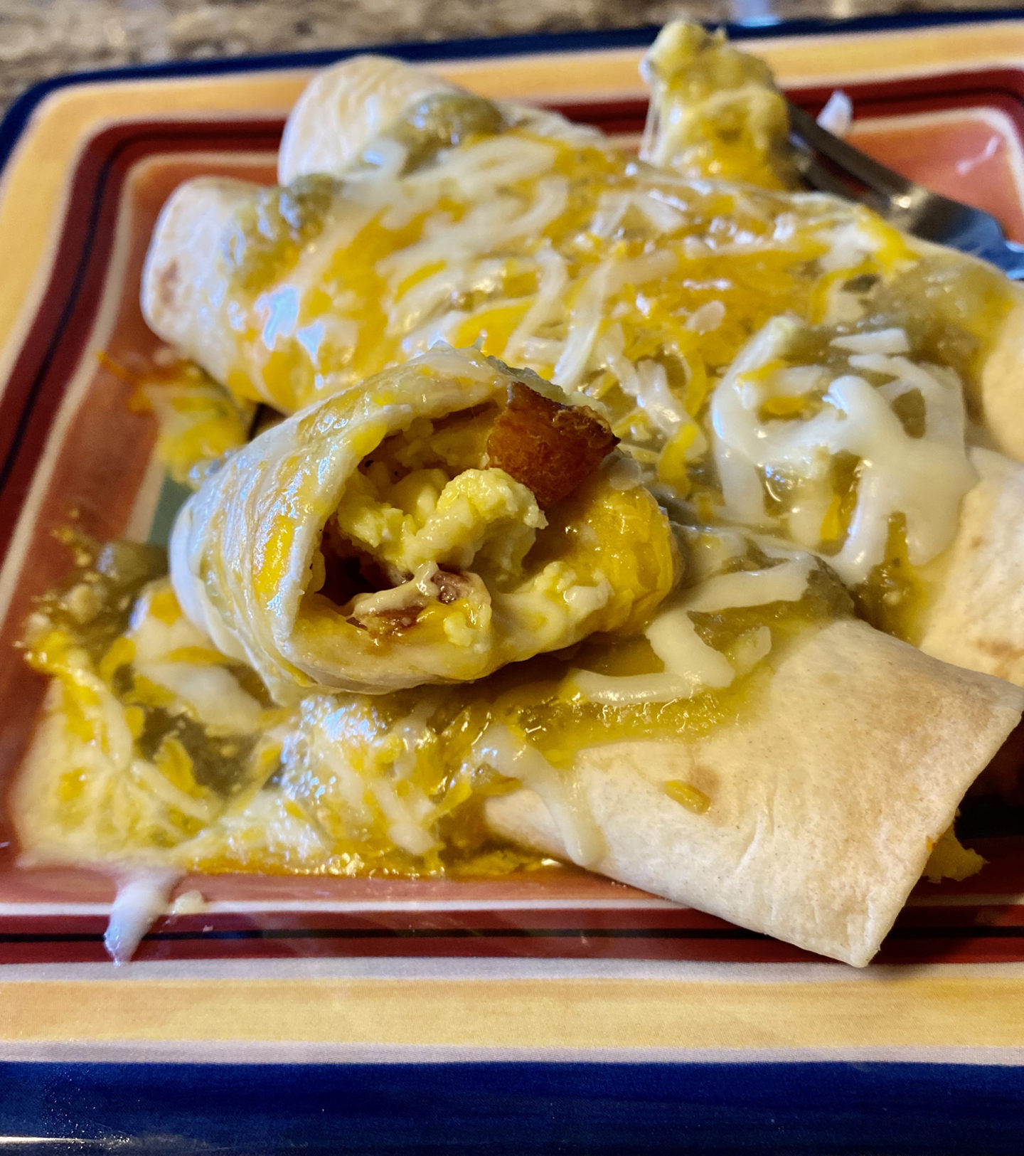 smothered egg bacon cheese breakfast taquito closeup of inside