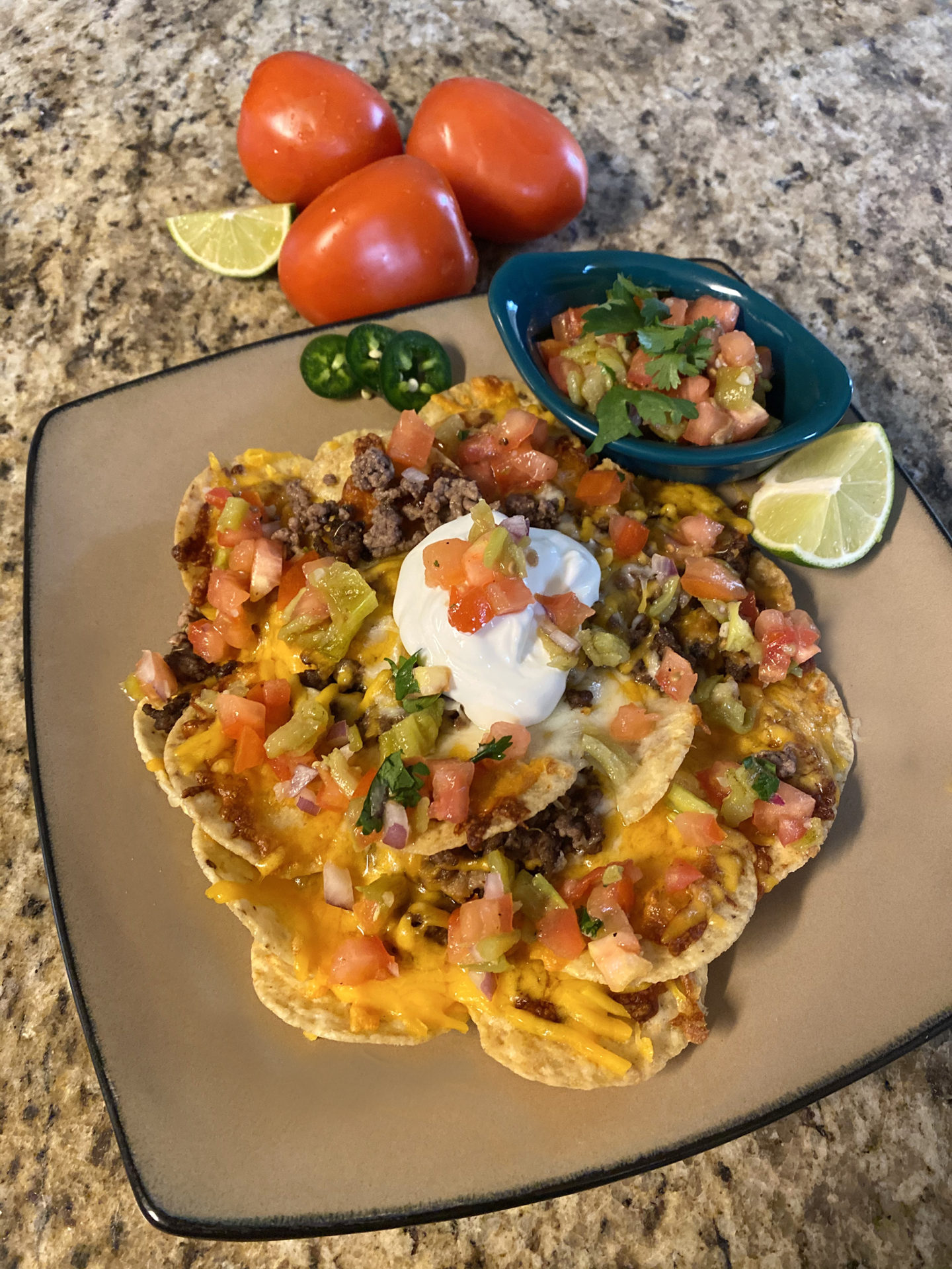 plate of loaded nachos with garnishes