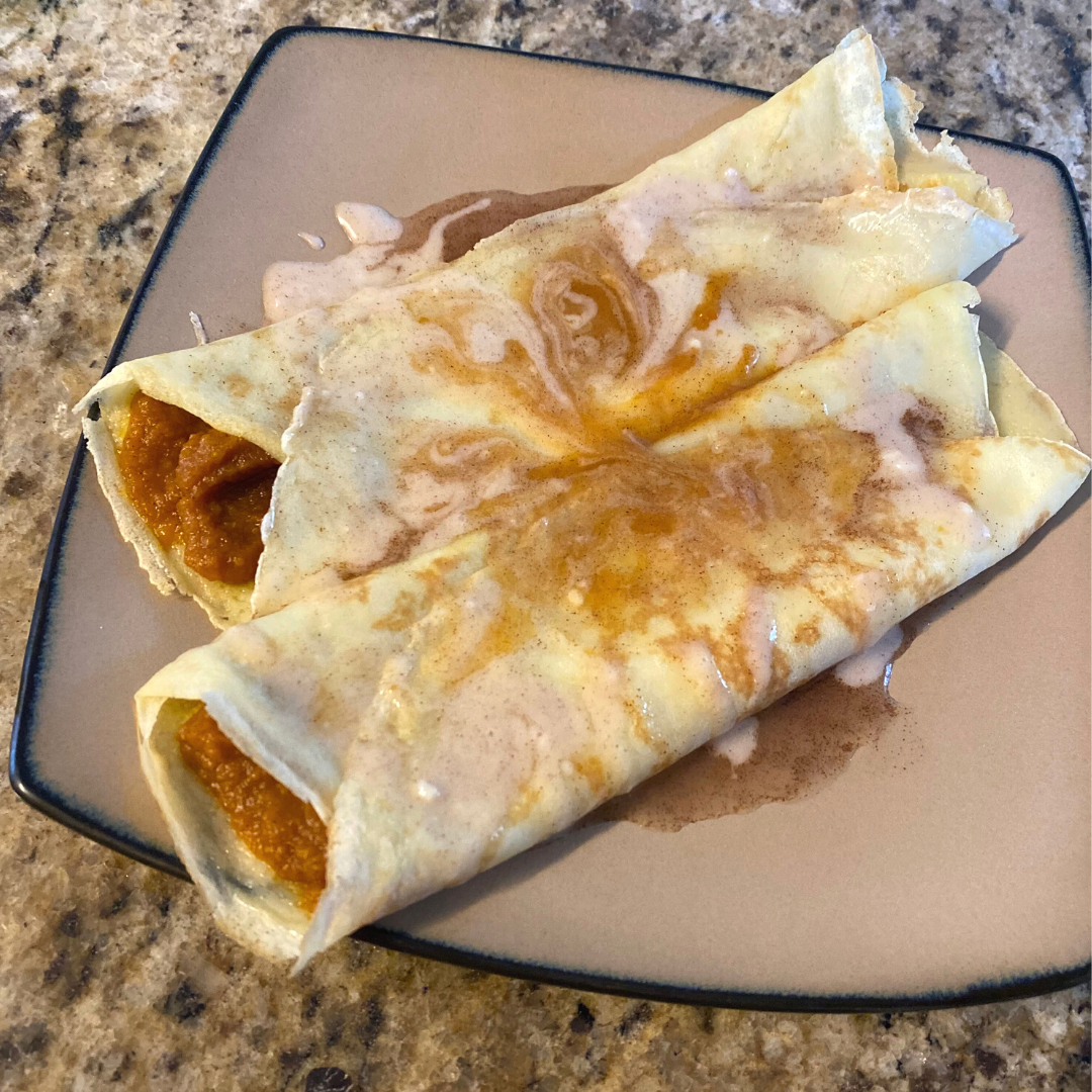 two filled pumpkin spice crepes on a plate