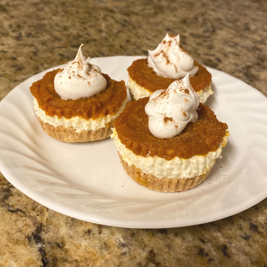 3 mini pumpkin spice cheesecakes on a white plate