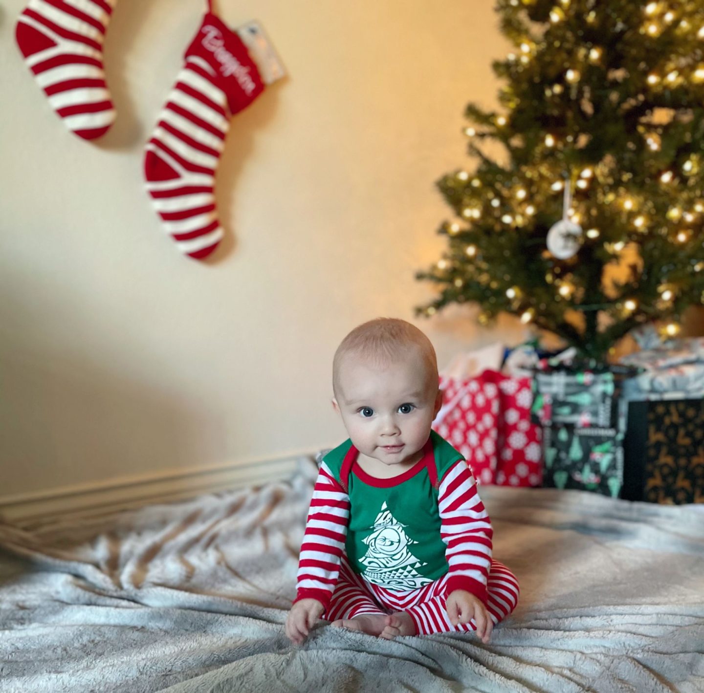 Baby B in christmas pjs by the tree
