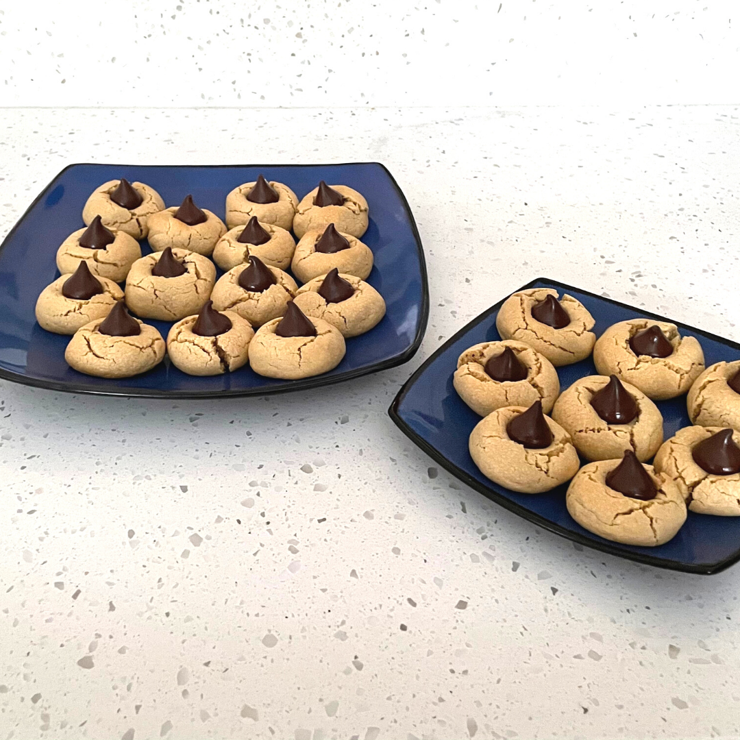 chocolate kisses thumbprint cookies on a blue square plate