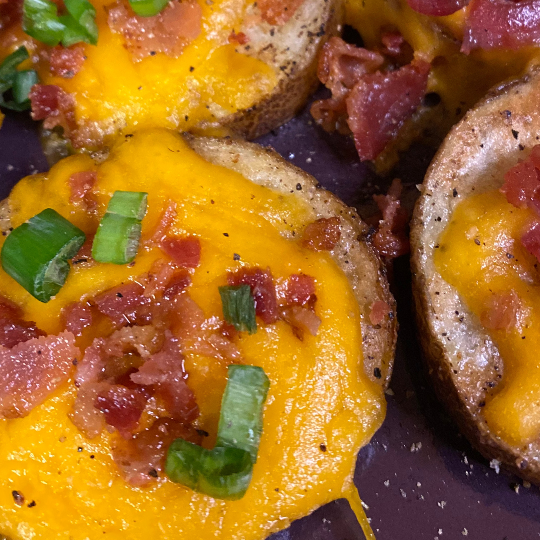 close up of baked potato slices with bacon cheese and green onions