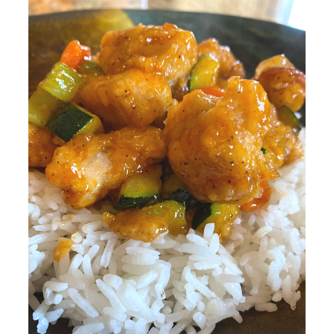close up of sweet and sour chicken with rice