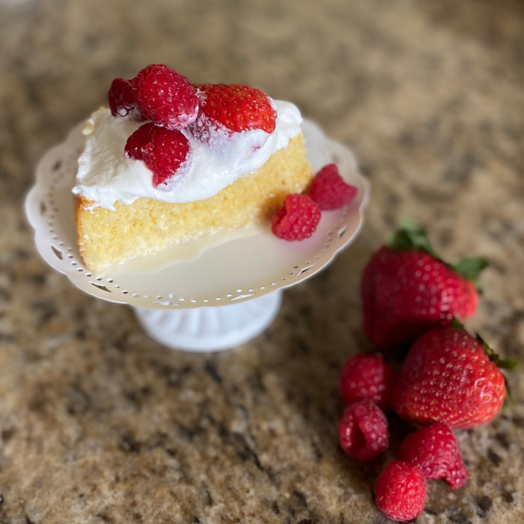 slice of tres leches cake with strawberries and raspberries