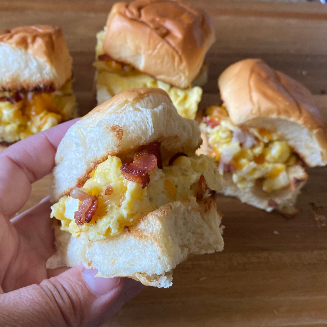 egg bacon and cheese breakfast sandwich minis held in hand