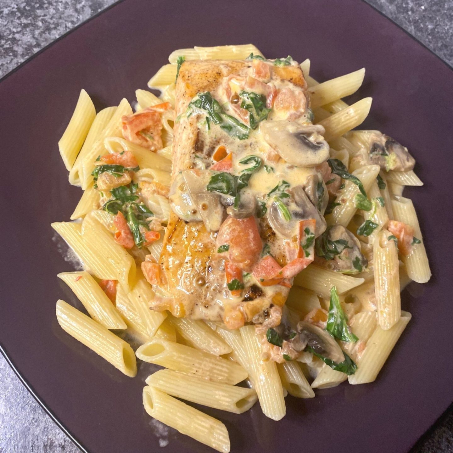 top view of creamy salmon and vegetable medley sauce on penne pasta