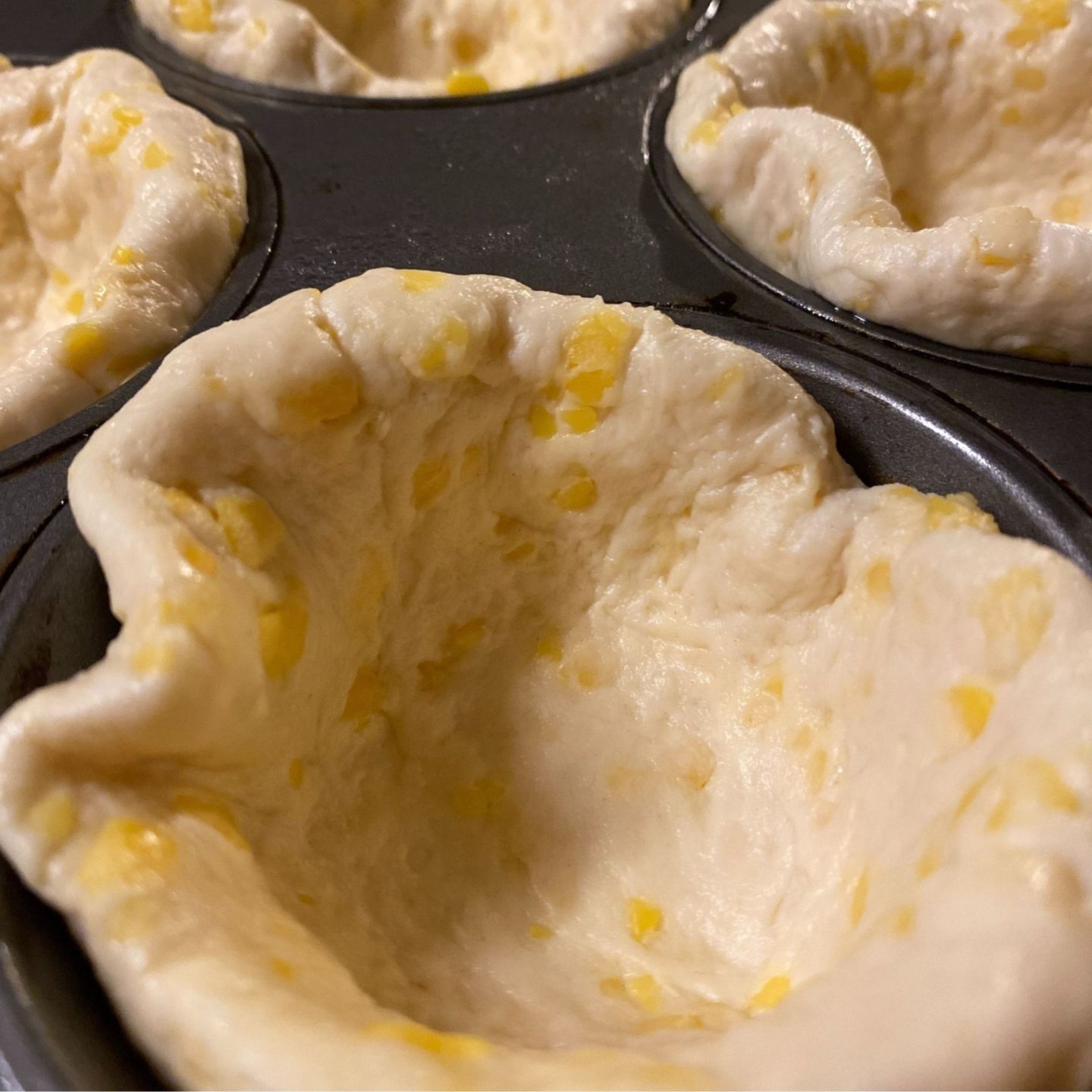 close up of biscuit dough in cupcake pan