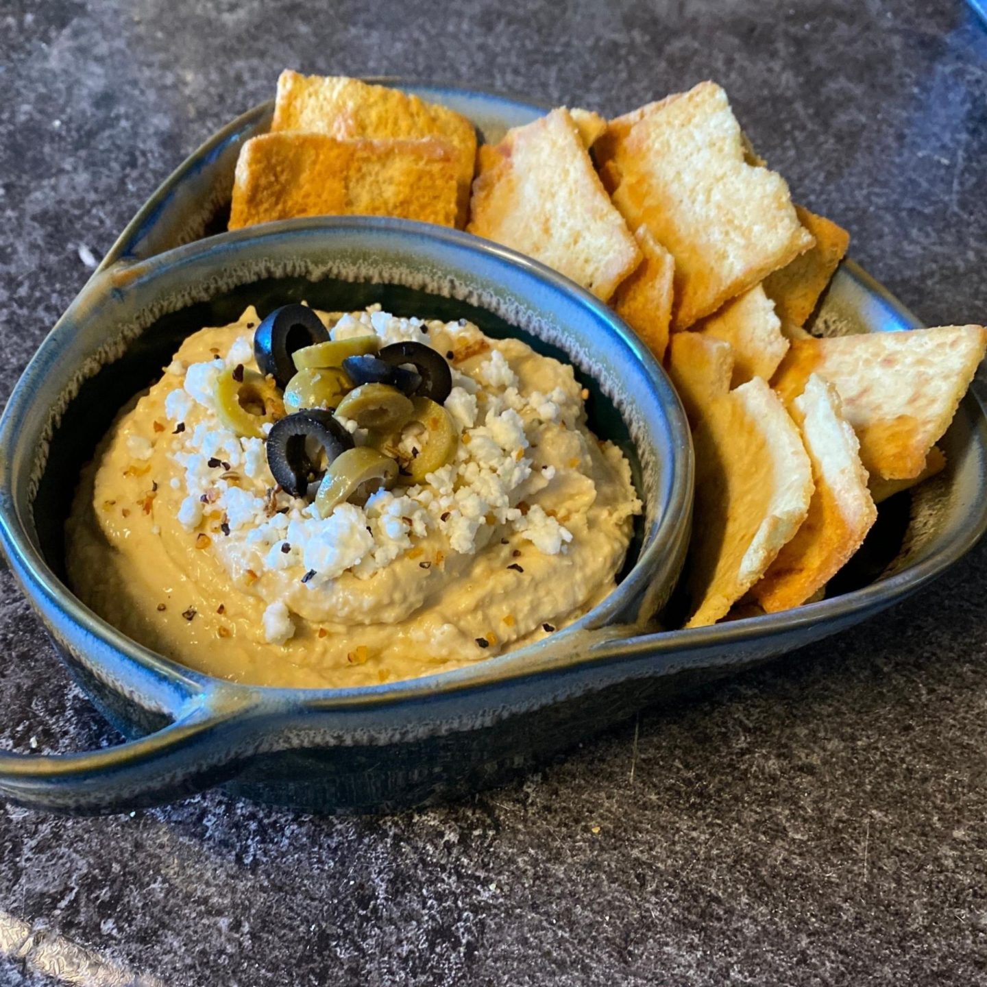 hummus with toppings with pits chips