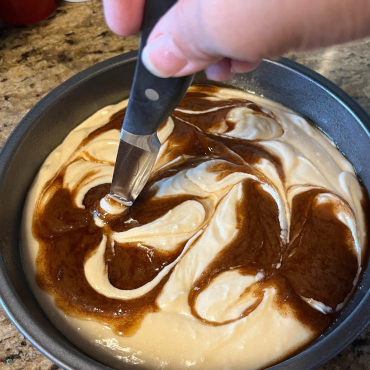 knife swirling cake and cinnamon roll batter