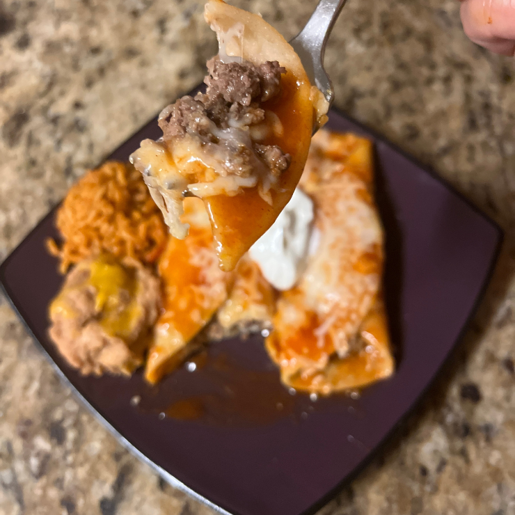 close up of beef enchilada piece on fork