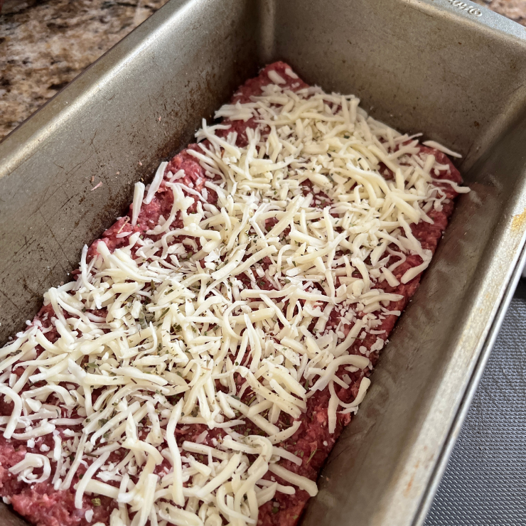 meatloaf in pan layered with cheese