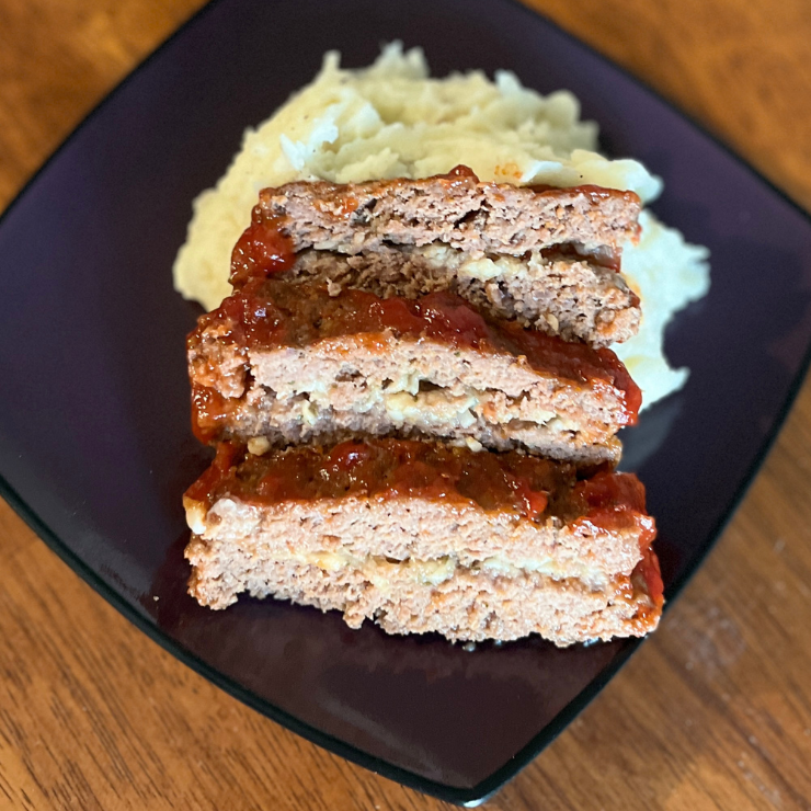 sliced meatloaf and mashed potatoes on plate