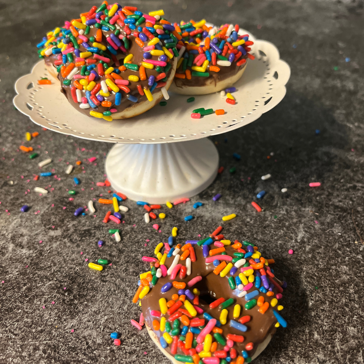 mini chocolate sprinkle donuts on white display holder