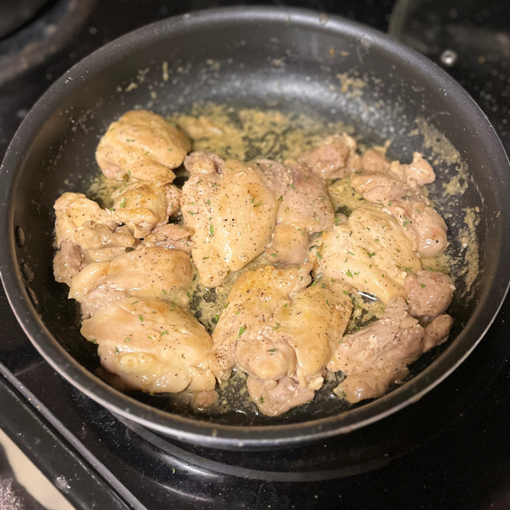 lightly browned chicken cooking in lemon butter 
